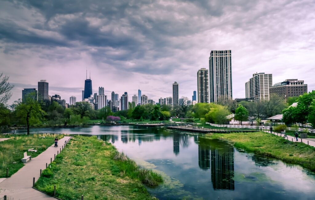 river near city buildings under cloudy sky