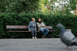 an elderly people sitting on a wooden bench while having conversation